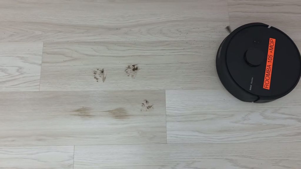 Roomba 105 Combo närmar sig utspritt skräp på ett trägolv