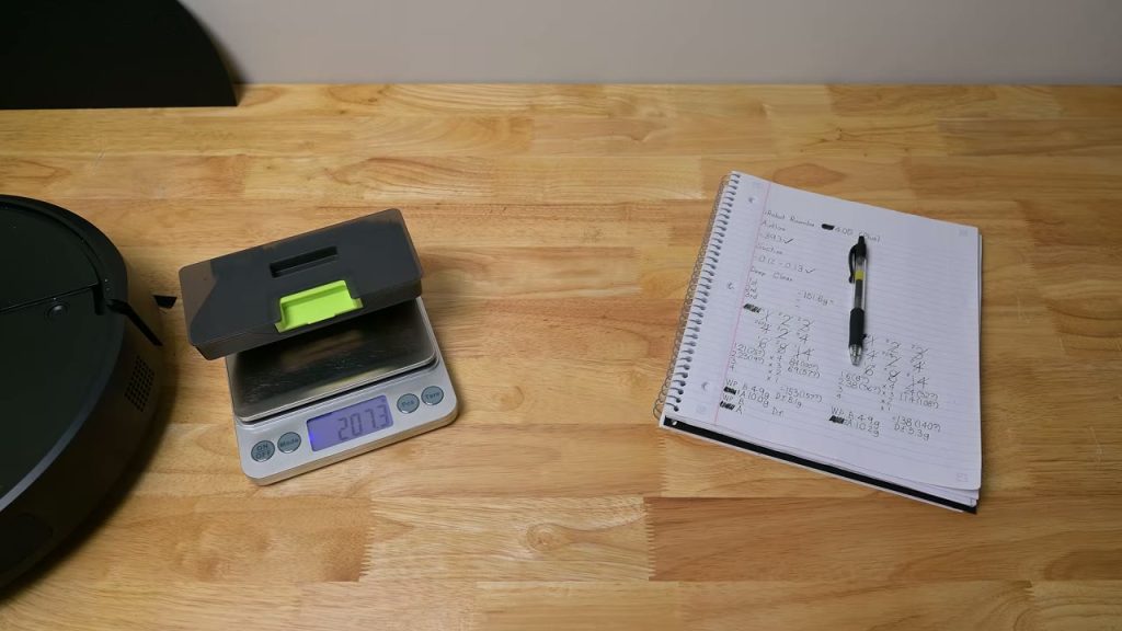 Testaren väger dammbehållaren från Roomba 405 Combo+