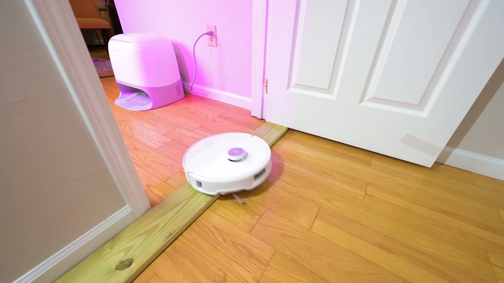 Roborock Qrevo Curv tar sig över en tröskel i en dörröppning