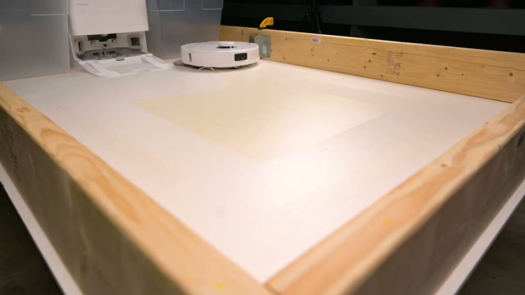 Roborock Qrevo MaxV och stationen vid testarens provgolv för moppning