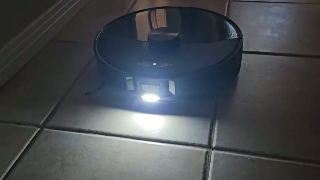 Roborock S8 MaxV Ultra med tänd frontbelysning på ett klinkergolv
