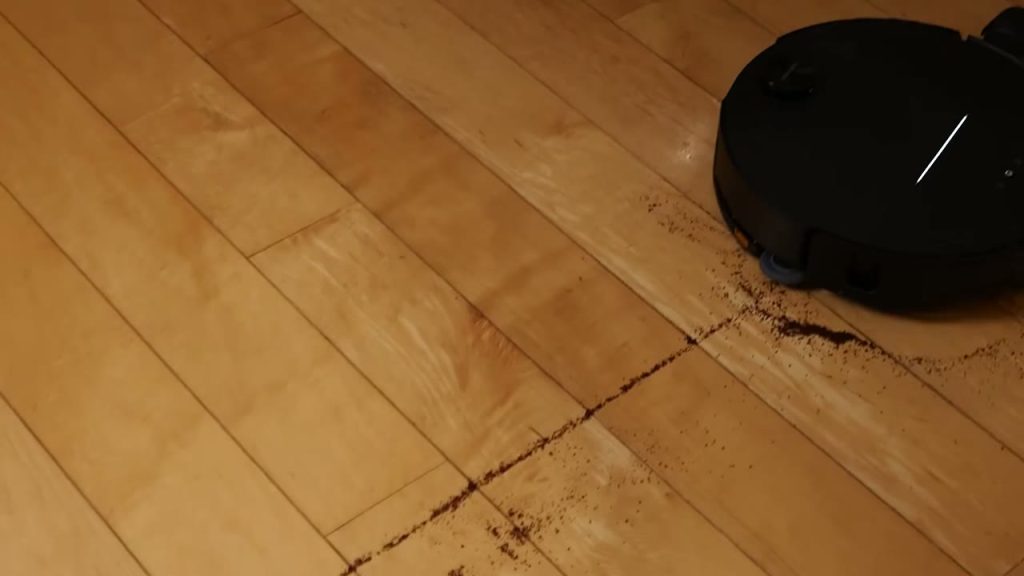 Roborock Saros 10 dammsuger upp utspridd smuts på ett trägolv